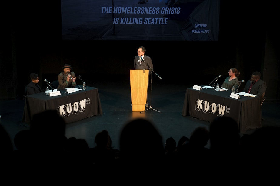 caption: Ross Reynolds moderates 'That's Debatable: The Homelessness Crisis is Killing Seattle' with debaters from left, Mellina White and Sergio Garcia arguing for the proposition, and Ashley Archibald and Dr. Lamont Green arguing against the proposition, on Tuesday, October 29, 2019, at Langston Hughes Performing Arts Institute in Seattle.