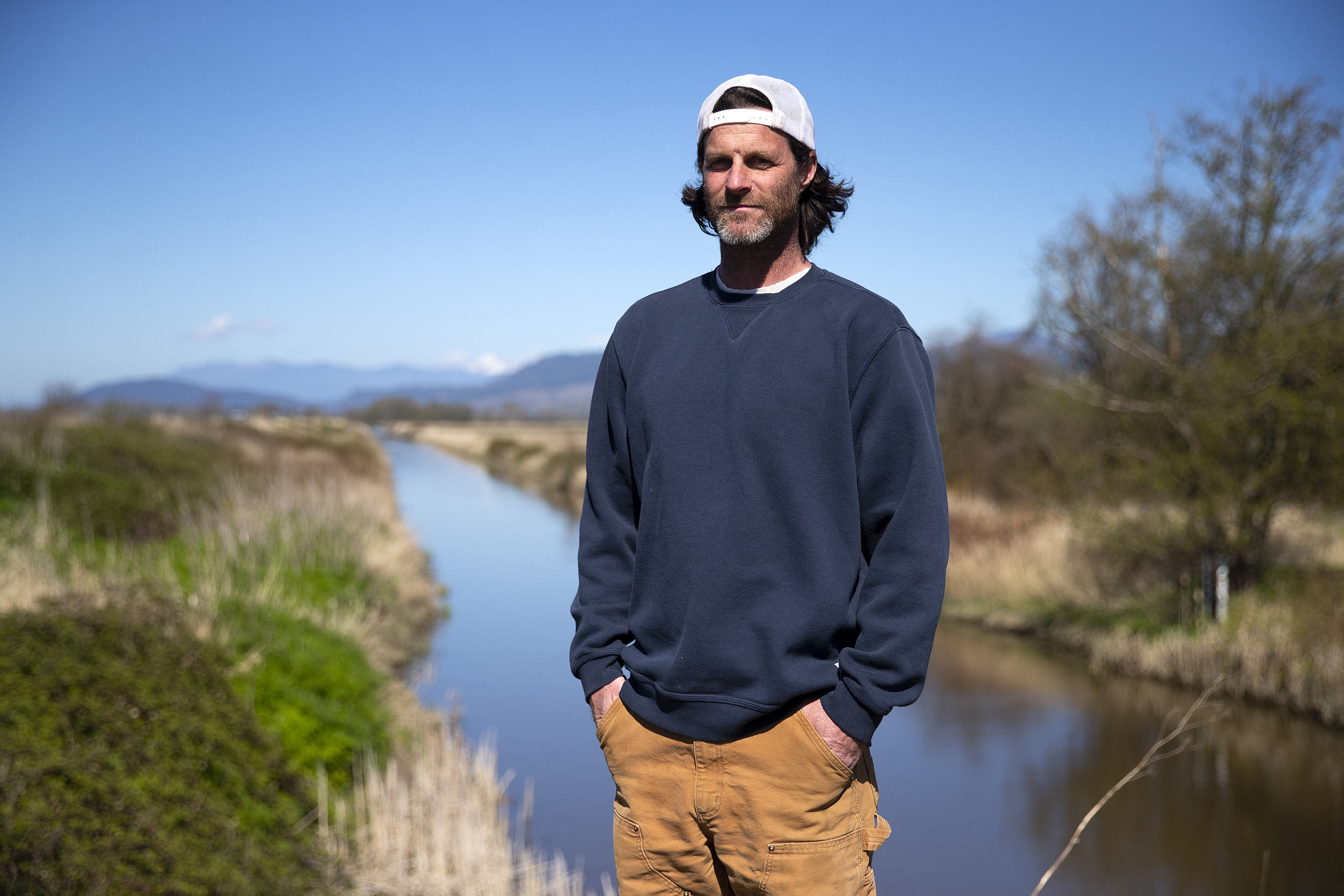 caption: Fifth generation farmer Tyler Breum is portrayed along the Tom Moore Slough levee, near Big Ditch, close to his family's farmland on Wednesday, April 8, 2026, in Stanwood, Washington.
