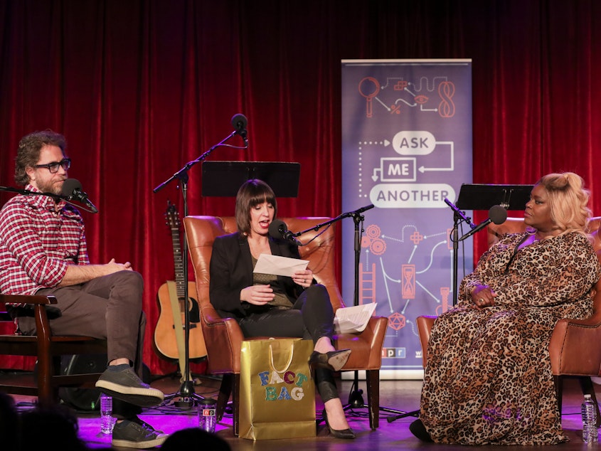 caption: Jonathan Coulton and Ophira Eisenberg play a round of Fact Bag with Retta, on <em>Ask Me Another</em> at the Bell House in Brooklyn, New York.