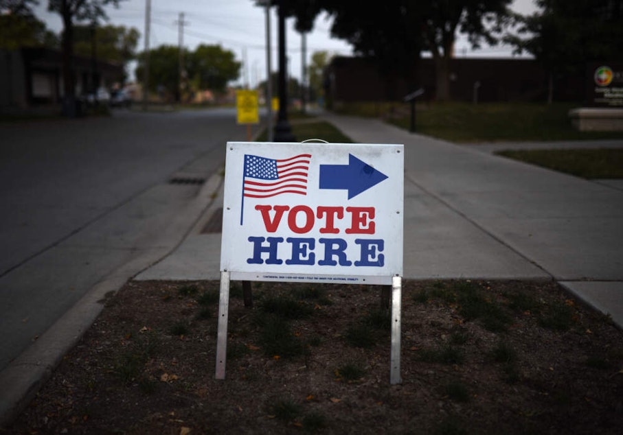 caption: A sign reading "Vote Here" points toward a polling place for the 2018 Minnesota primary election at Holy Trinity Lutheran Church on Aug. 14, 2018 in Minneapolis, Minnesota. (Stephen Maturen/Getty Images)