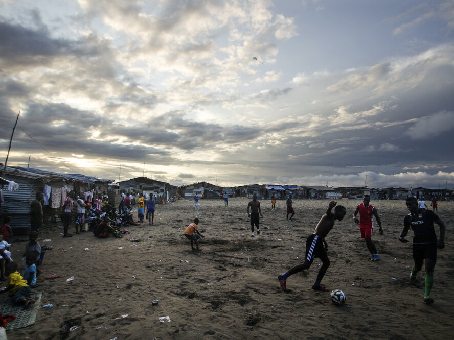 caption: Thanksgiving is a day at the beach — quite literally — for young Liberians. Above, the beach in West Point is a sandy playing field for soccer lovers.