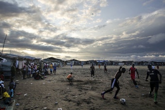 caption: Thanksgiving is a day at the beach — quite literally — for young Liberians. Above, the beach in West Point is a sandy playing field for soccer lovers.