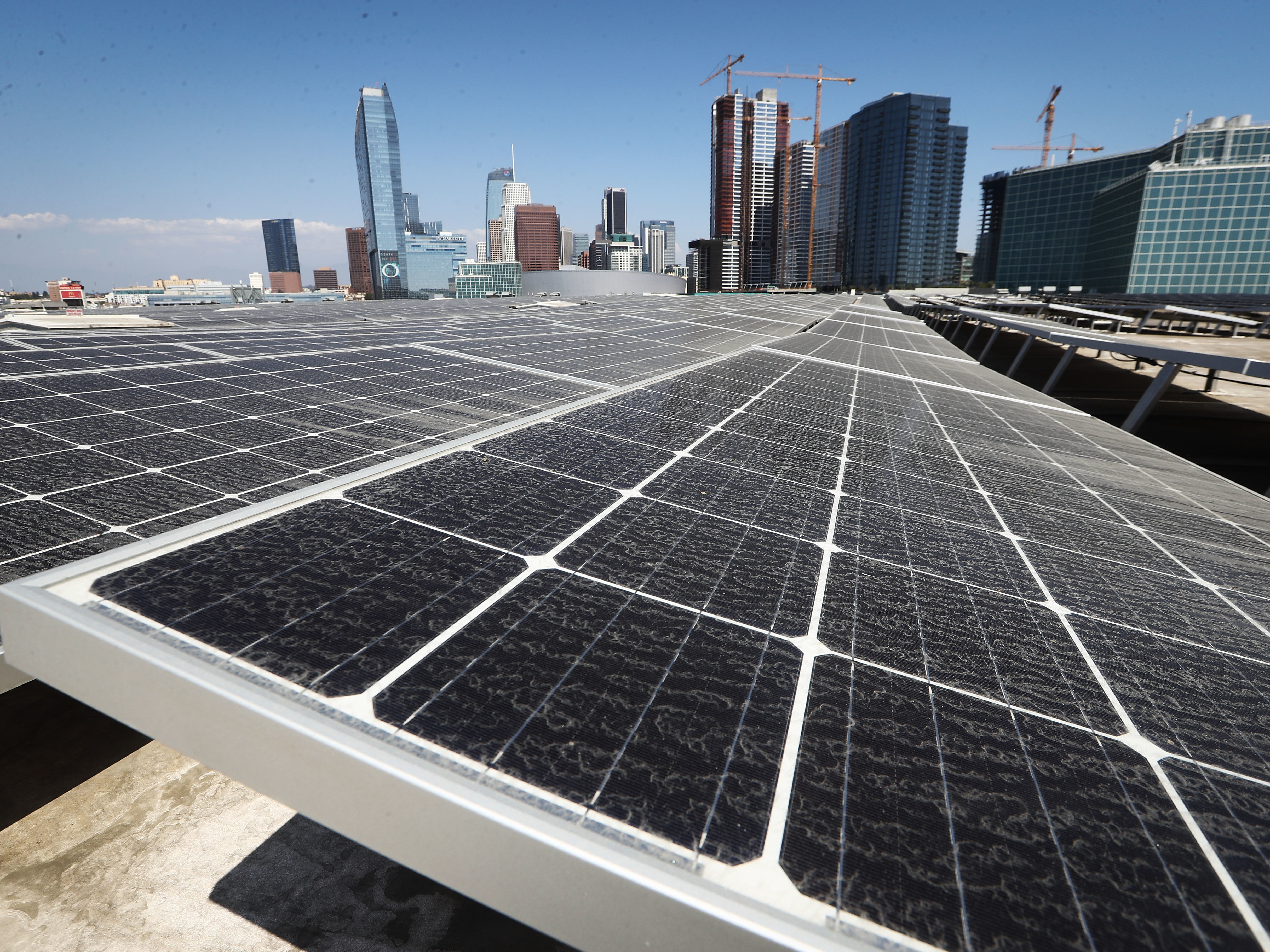 caption: Solar panels are mounted on the roof of the Los Angeles Convention Center on September 5. The state's governor has signed a landmark bill setting a goal of 100 percent clean energy for the state's electrical needs, by the year 2045.