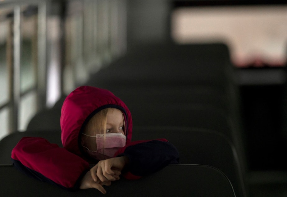 caption: A first-grade student sits on the bus after a day of classes in Woodland, Wash., on Thursday.