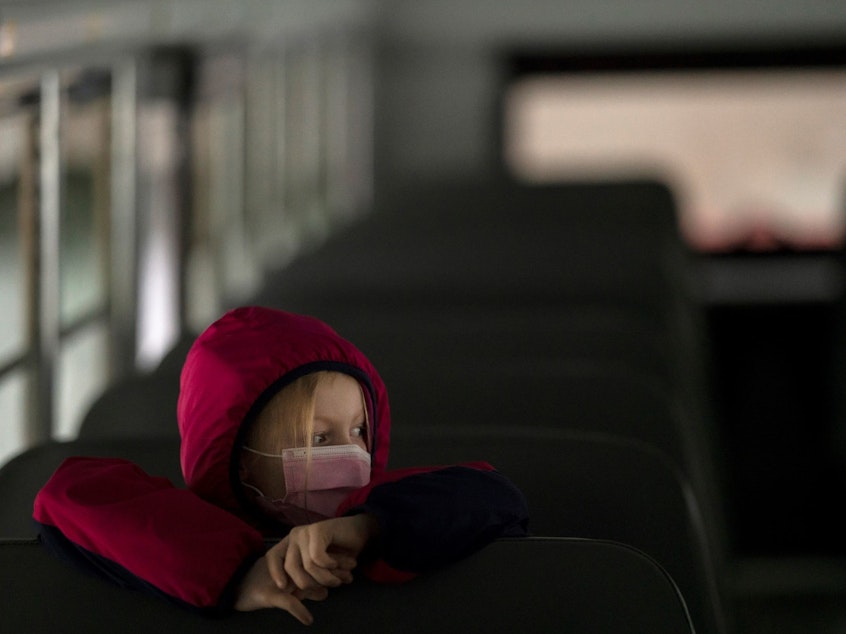 caption: A first-grade student sits on the bus after a day of classes in Woodland, Wash., on Thursday.