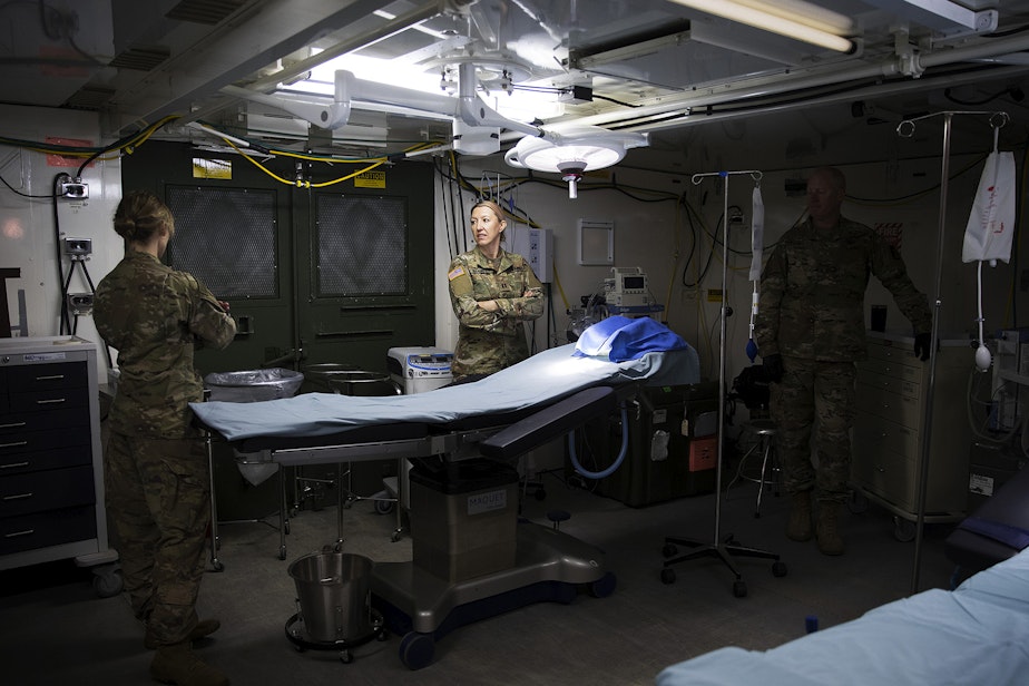 caption: U.S. Army soldiers are shown in the operating room of a military field hospital set up by soldiers from the 627th Army Hospital from Fort Carson, Colorado, as well as from Joint Base Lewis-McChord on Tuesday, March 31, 2020, at the CenturyLink Field Event Center in Seattle. The 250-bed hospital will be for non COVID-19 patients. 