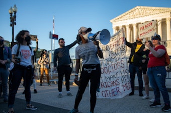 caption: Abortion rights demonstrators chant during a protest outside the Supreme Court on Tuesday.