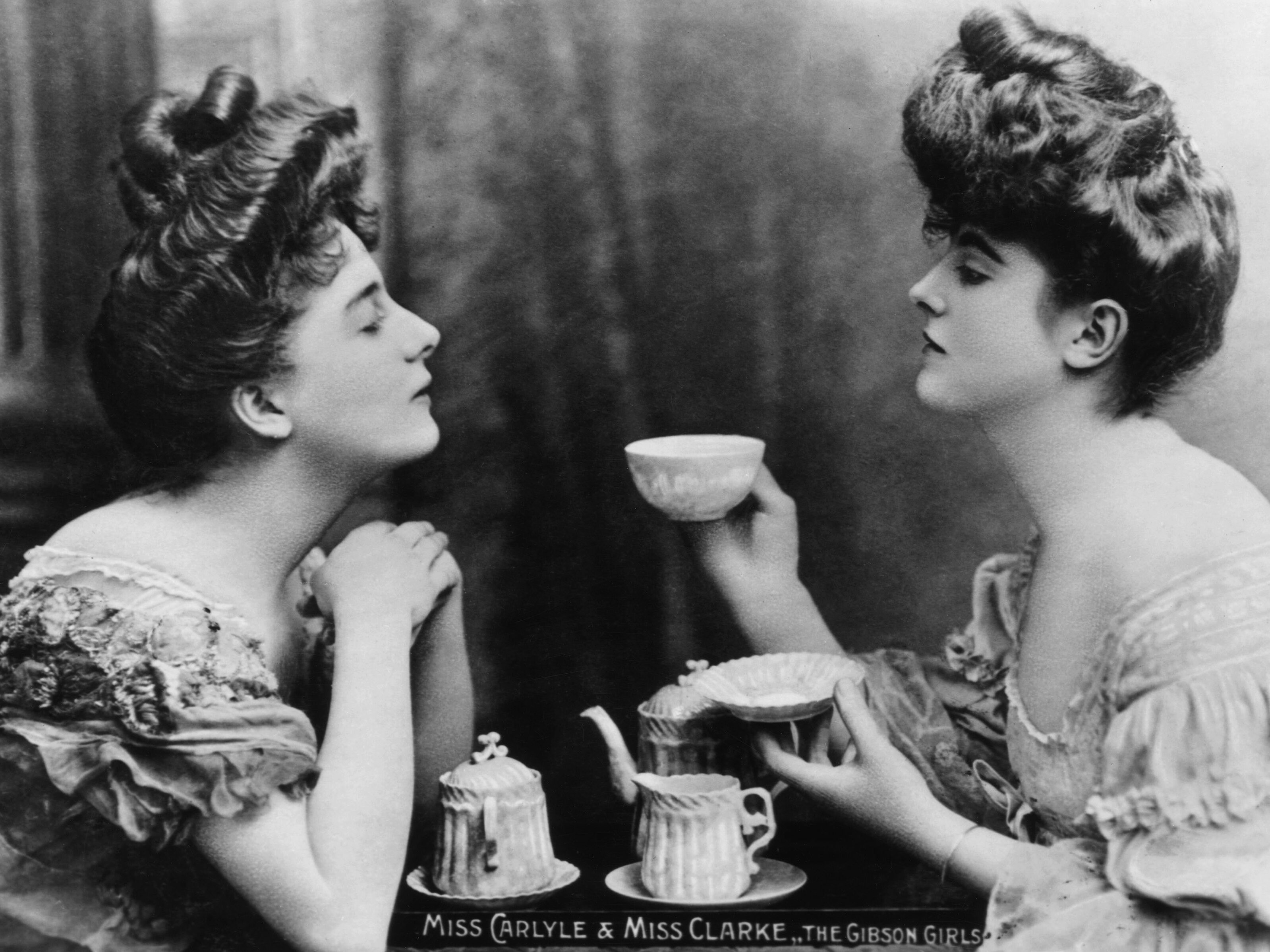 caption: "Gibson Girls" Miss Carlyle and Miss Clarke take tea. Gibson Girls were a tall, slim-waisted type of women characterized by the drawings of American society illustrator Charles Gibson circa 1905.