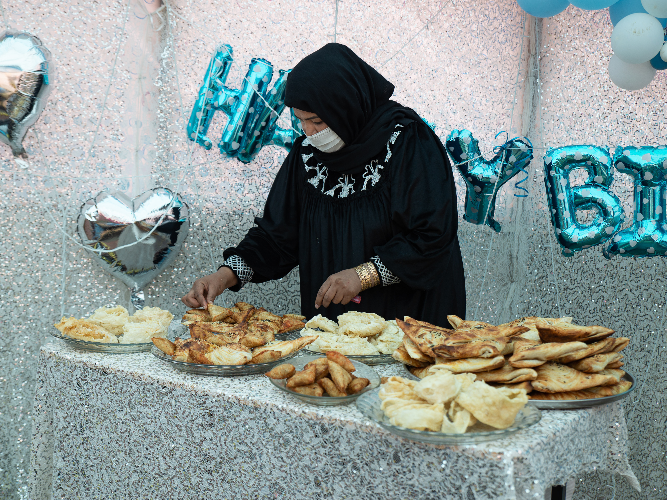 caption: Samira Muhammadi, the owner of Banowan-e-Afghan restaurant, prepares food for a birthday party.