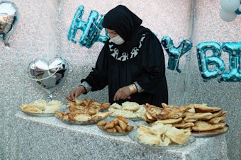 caption: Samira Muhammadi, the owner of Banowan-e-Afghan restaurant, prepares food for a birthday party.