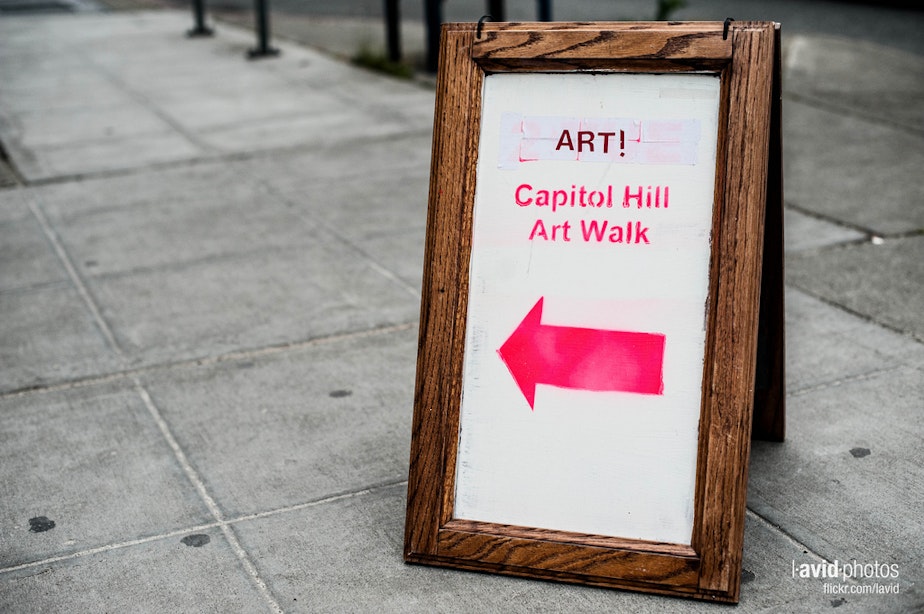 caption: A sign points towards an exhibit as part of a 2012 art walk on Capitol Hill, Seattle.