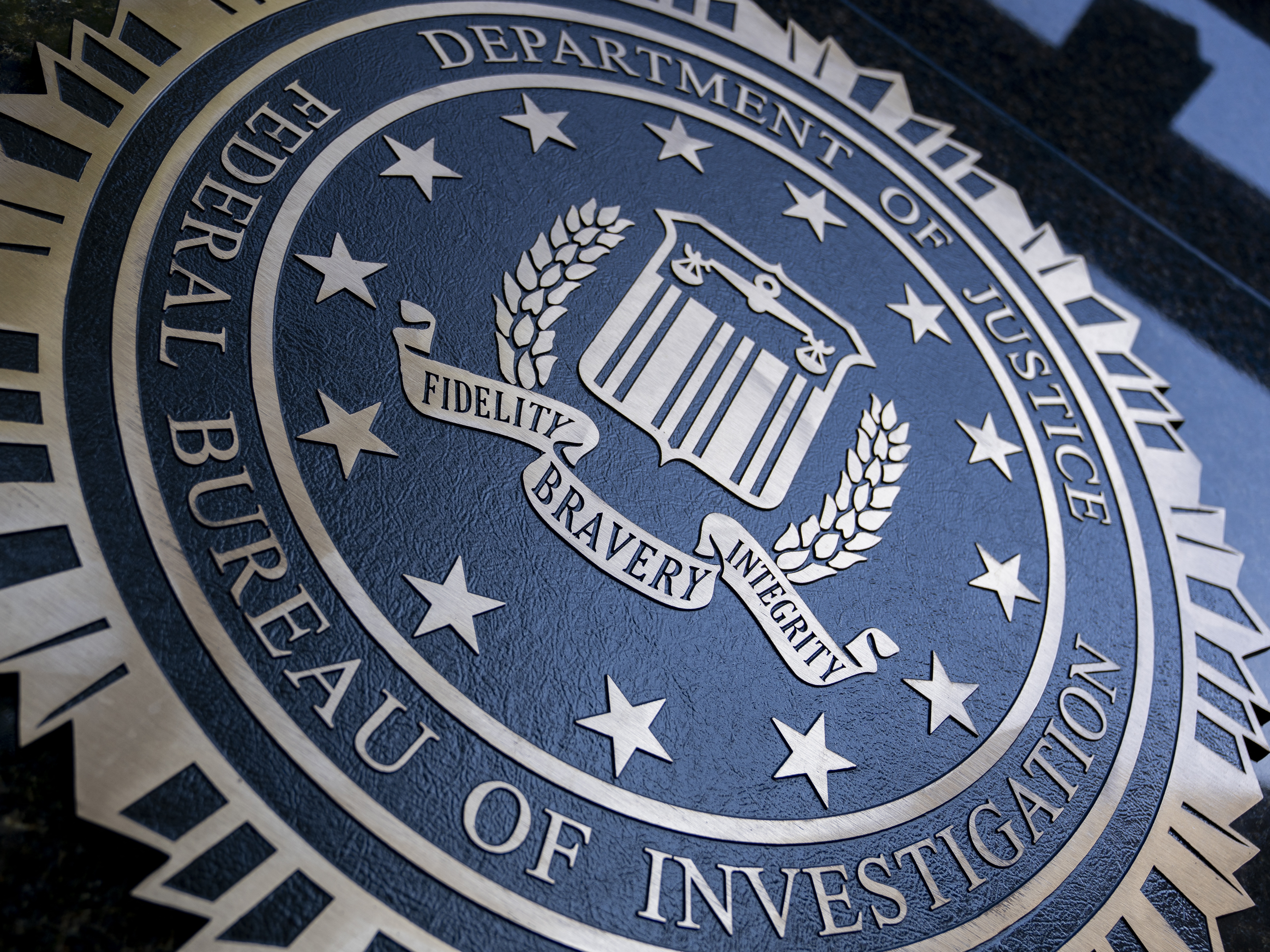 caption: A seal reading "Department of Justice Federal Bureau of Investigation" is displayed on the J. Edgar Hoover FBI building in Washington, D.C. in 2022.
