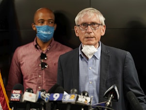 caption: Wisconsin Gov. Tony Evers announced the National Guard will be deployed ahead of a decision whether to charge a police officer who shot Jacob Blake last year. Evers is seen during a press conference in August.