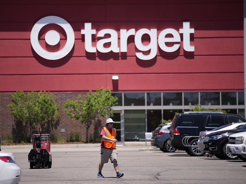 caption: A worker collects shopping carts in the parking lot of a Target store on June 9, 2021, in Highlands Ranch, Colo.
