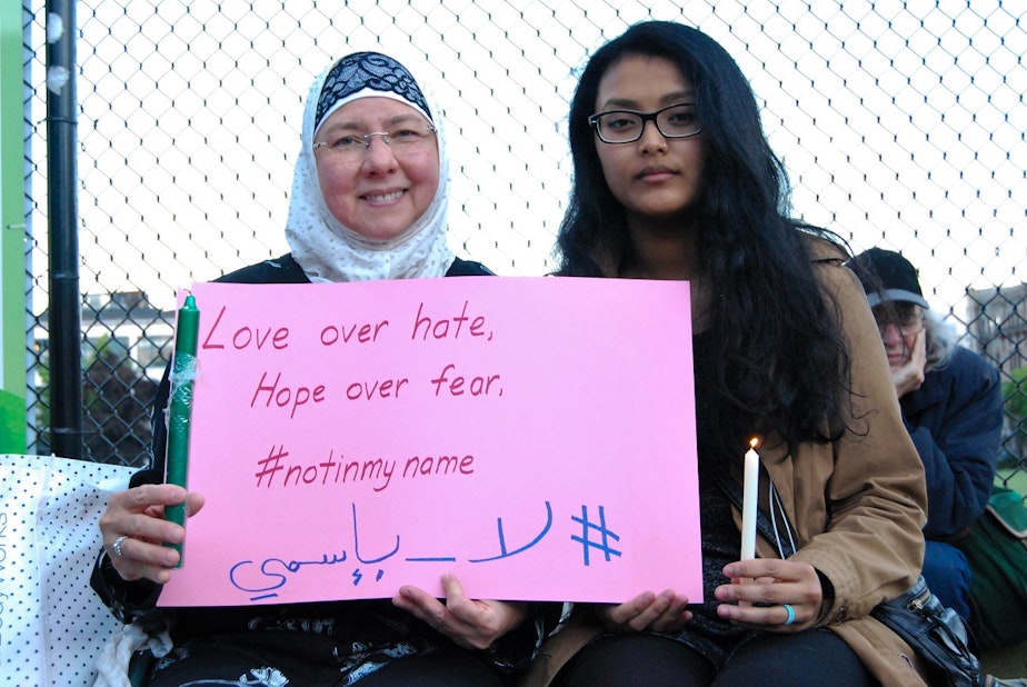 caption: Aishah Jilani, left, wrote the hashtag #notinmyname in Arabic during a vigil at Cal Anderson Park for the victims of the Orlando shooting. 