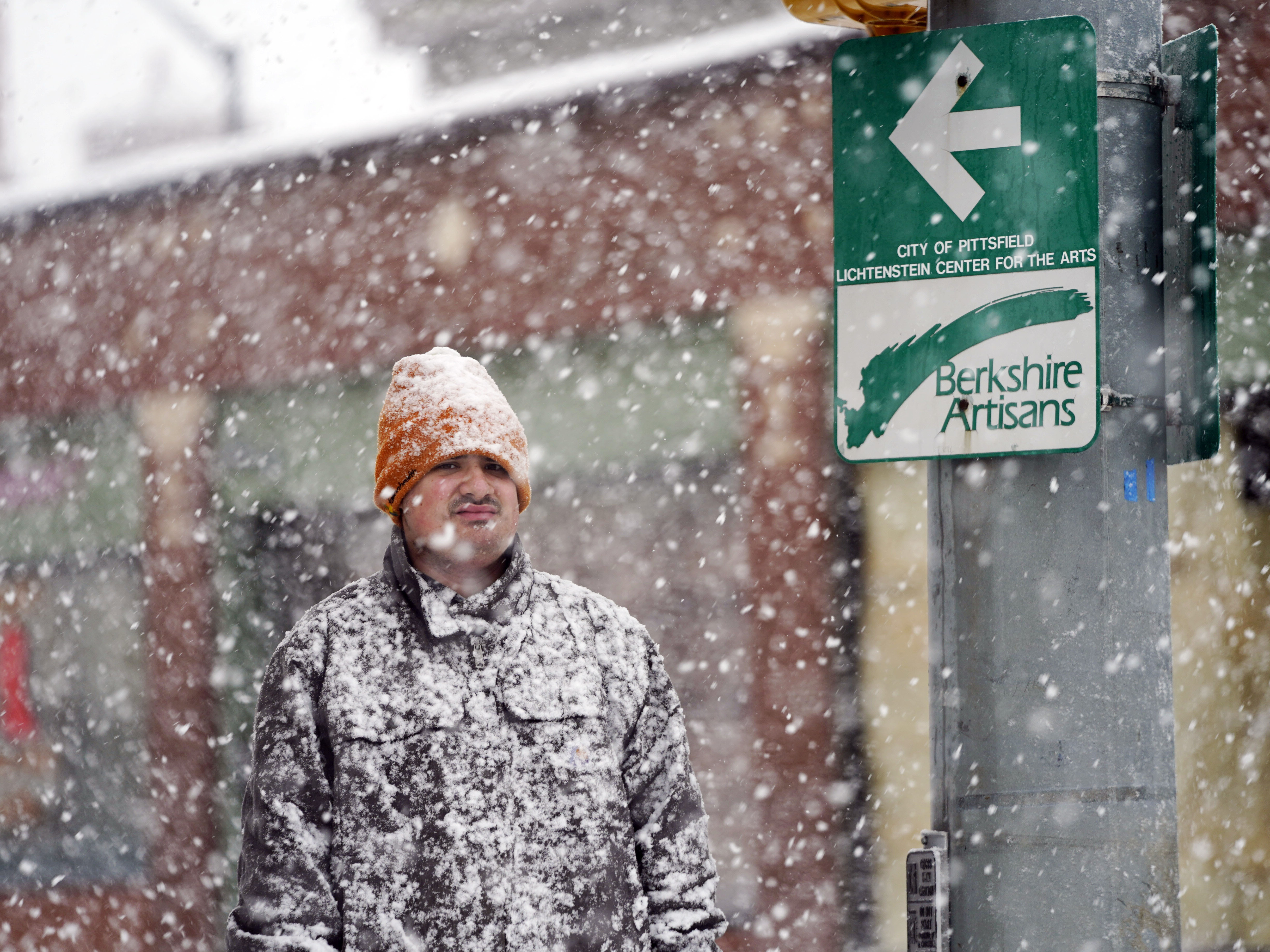 caption: A man is covered in snow on Fenn Street in Pittsfield, Mass., Dec. 16, 2022.
