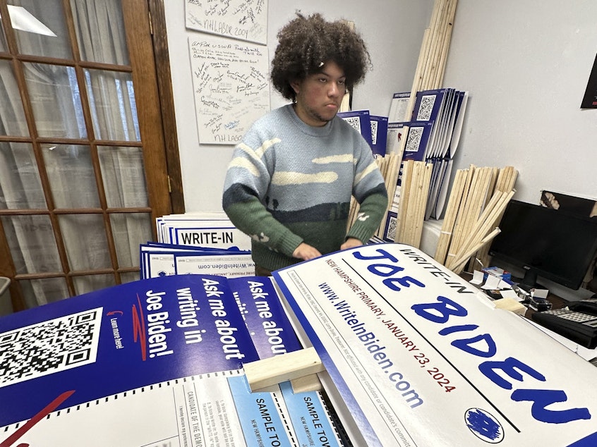 caption: Malikiah Guillory, 19, stacks yard signs in Hooksett, N.H., on Wednesday, urging voters to write in President Biden's name on the Democratic primary ballot. Biden is skipping the New Hampshire primary because it didn't comply with party rules.