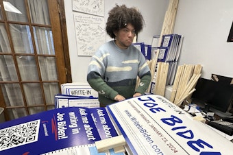 caption: Malikiah Guillory, 19, stacks yard signs in Hooksett, N.H., on Wednesday, urging voters to write in President Biden's name on the Democratic primary ballot. Biden is skipping the New Hampshire primary because it didn't comply with party rules.