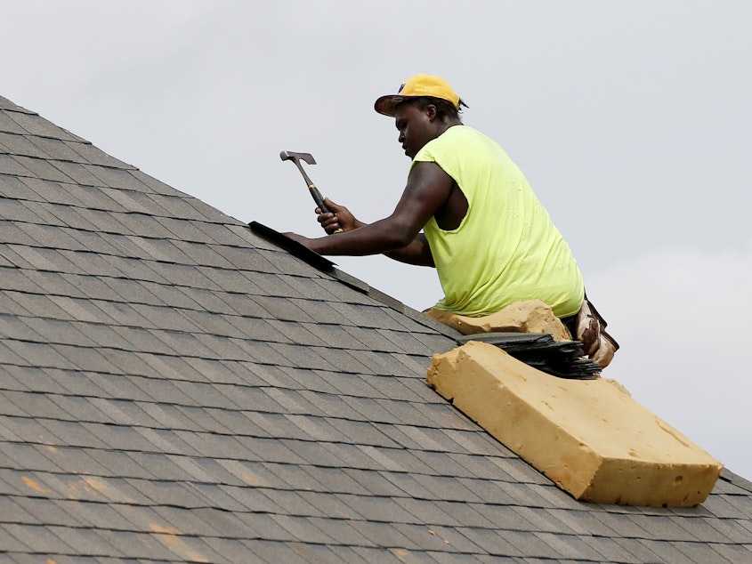 caption: A construction worker lays down shingles on the roof of a new house in Brandon, Miss., on June 19. Construction jobs rose 4,000 in July — below the 18,000 added in June and the 19,000 added in July 2018.