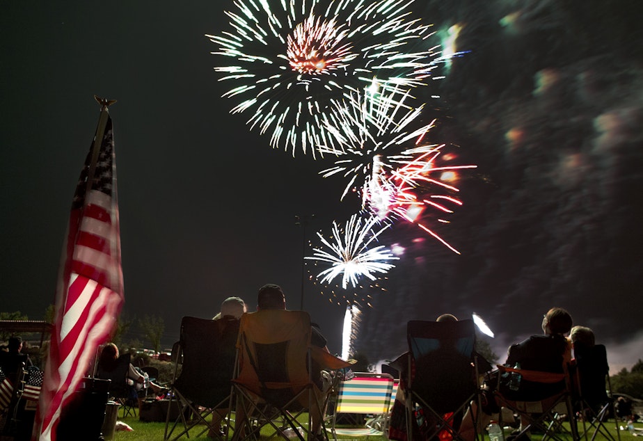 caption: Spectators watch as fireworks explode overhead during the Fourth of July celebration at Pioneer Park, on July 4, 2013, in Prescott, Ariz.
