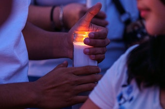 caption: Mourners hold candles as they gather for a vigil at a memorial outside Cielo Vista Walmart in El Paso, Texas, U.S., on Wednesday, Aug. 7, 2019.