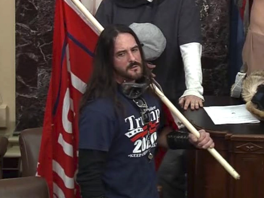 caption: In this image from U.S. Capitol Police video, Paul Hodgkins of Tampa, Fla., stands in the well on the floor of the U.S. Senate on Jan. 6. On Monday he was sentenced to eight months in prison.