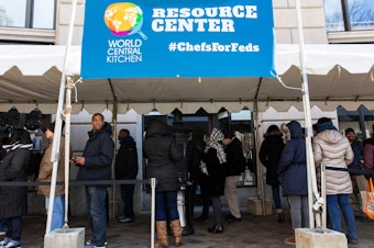 caption: Federal employees wait in line at World Central Kitchen, a food bank and food distribution center established by celebrity chef José Andrés. The federal government is back open, but it could be several days before workers receive missed paychecks.