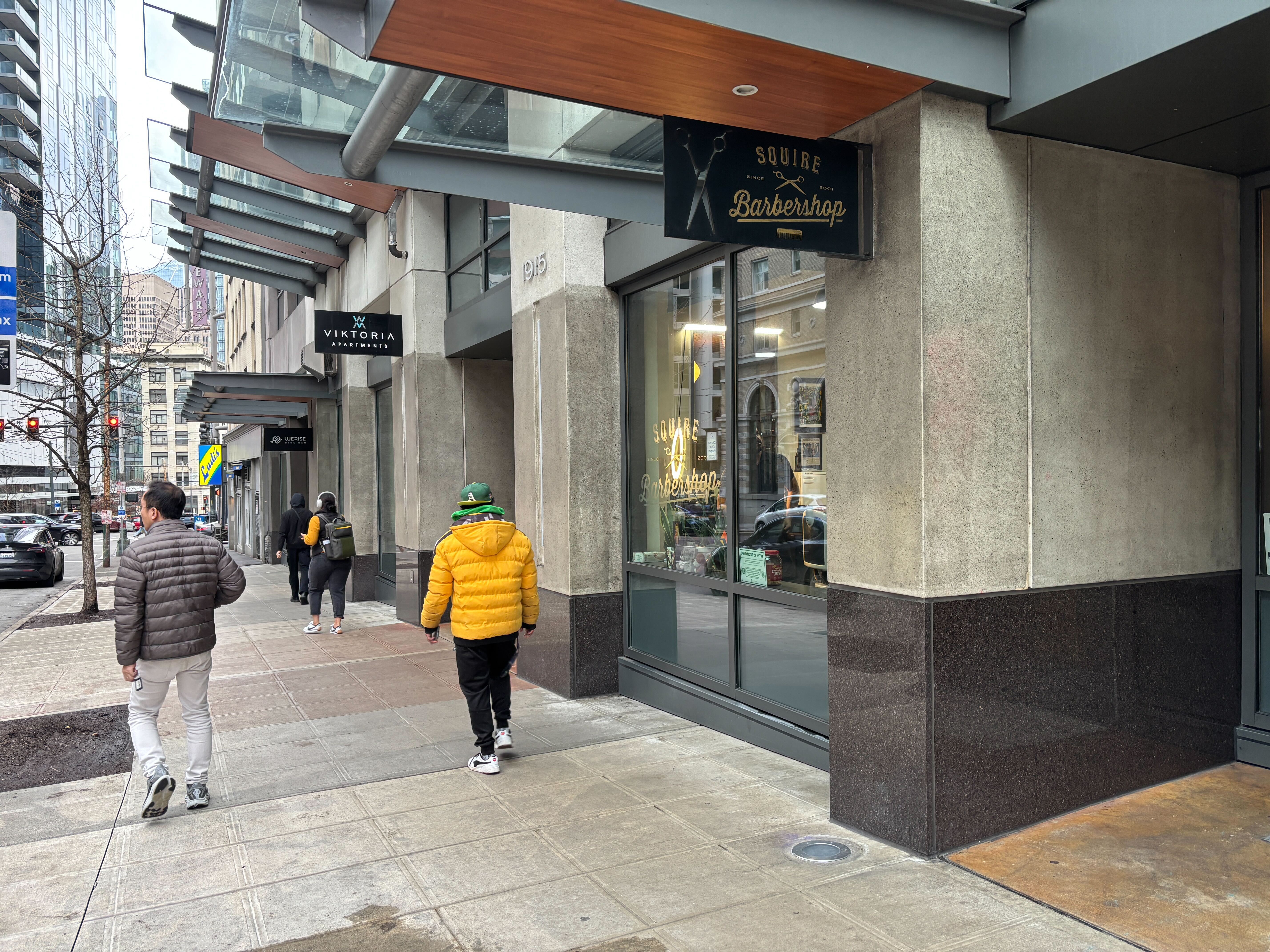 caption: The Squire Barbershop occupies a storefront below an apartment building in downtown Seattle.