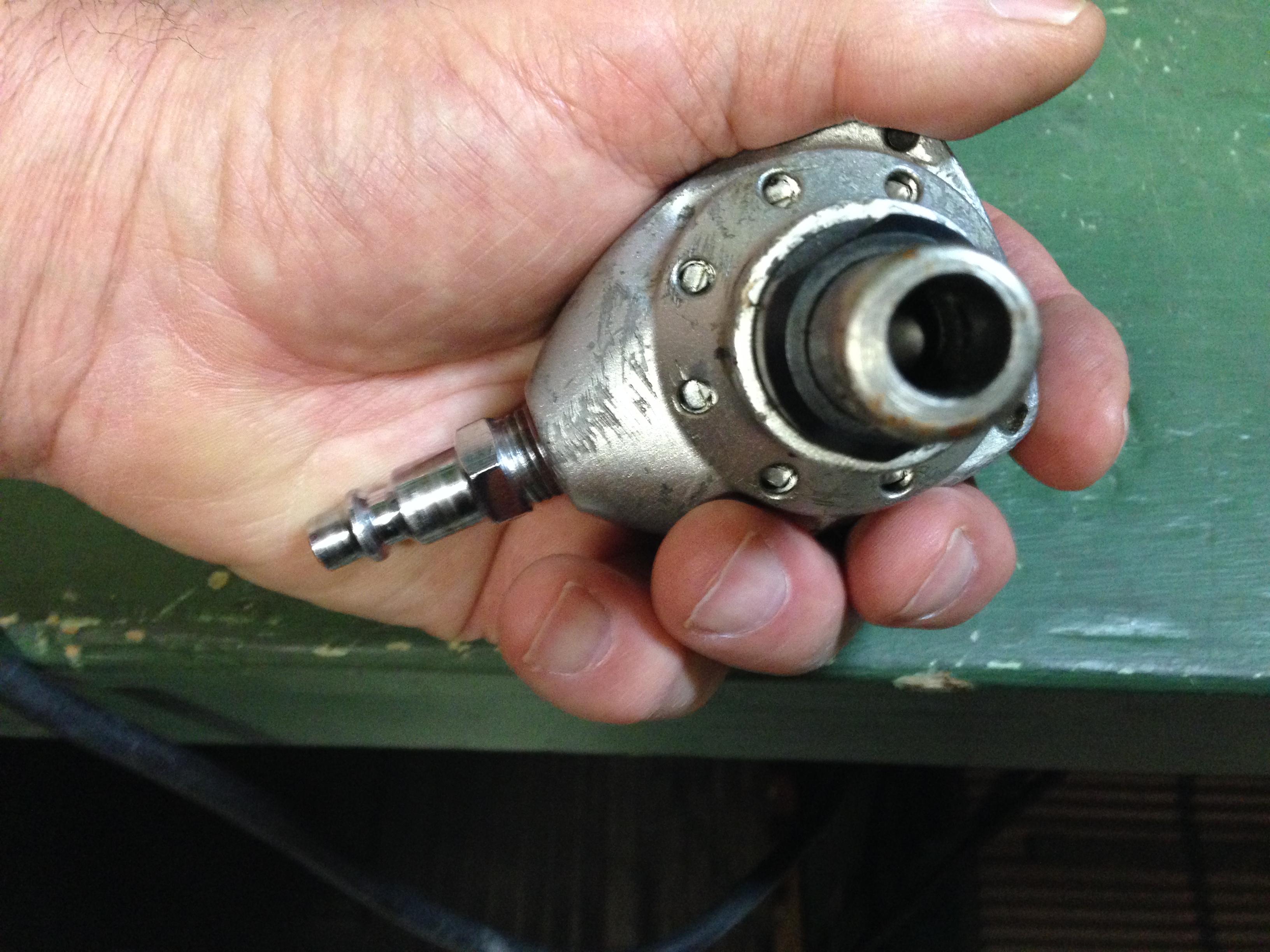 caption: Roger Faris holds a pneumatic hand nailer.