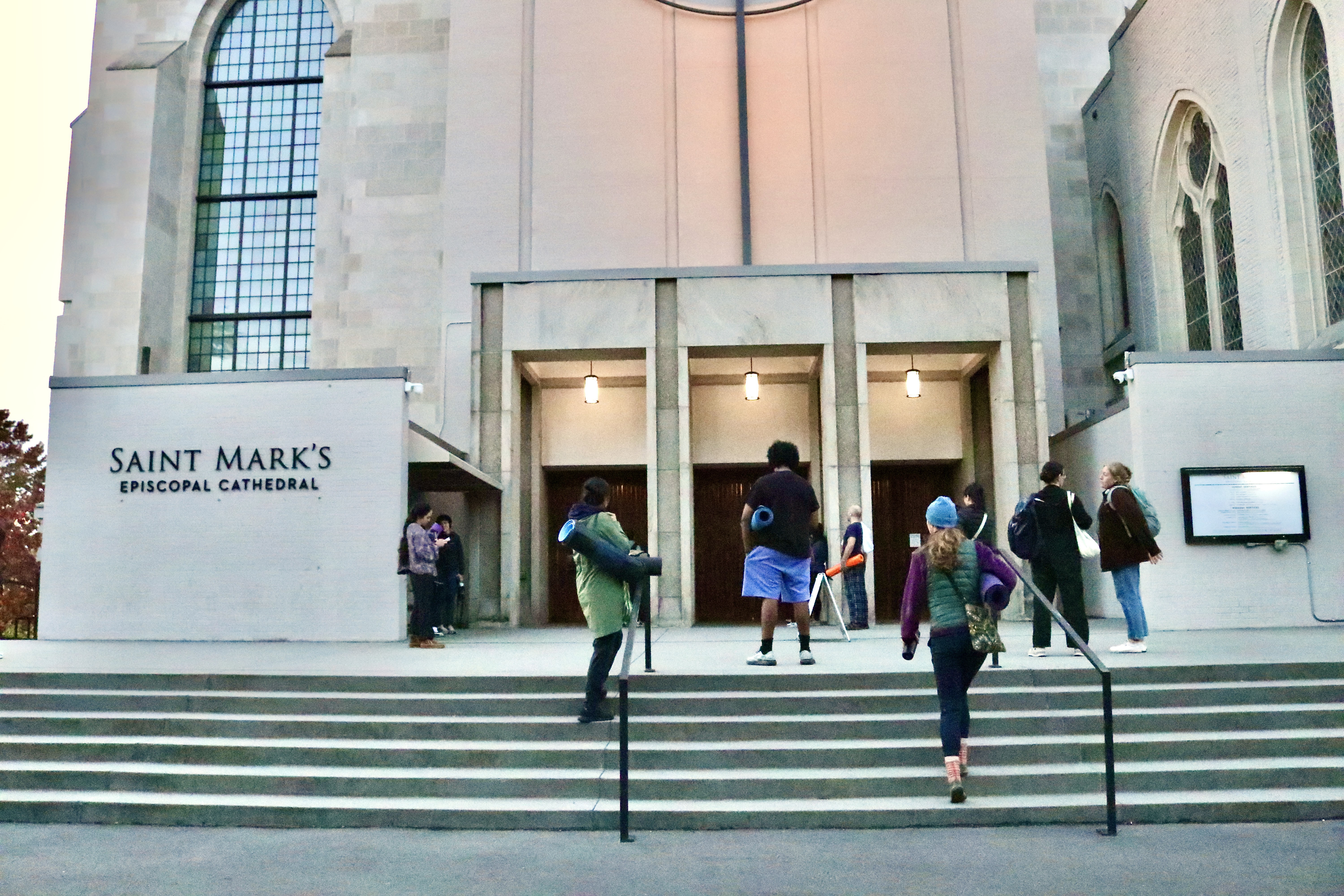 caption: Participants start entering the cathedral to begin the yoga class. 