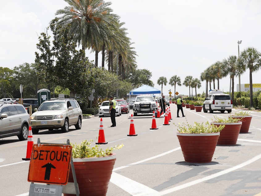 caption: Cars line up for drive-through coronavirus testing in St. Petersburg, Florida. The state reported a record-breaking 15,299 new cases on Sunday.