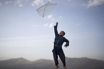 caption: In this photo made by Associated Press photographer Anja Niedringhaus, an Afghan boy flies his kite on a hill overlooking Kabul, Afghanistan, May 13, 2013.