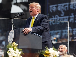 caption: President Trump speaks at the "Namaste Trump" event at Sardar Patel Gujarat Stadium in Ahmedabad, India, on Monday as Indian Prime Minister Narendra Modi looks on. Trump said the two leaders were discussing a possible trade deal and called Modi "a very tough negotiator."