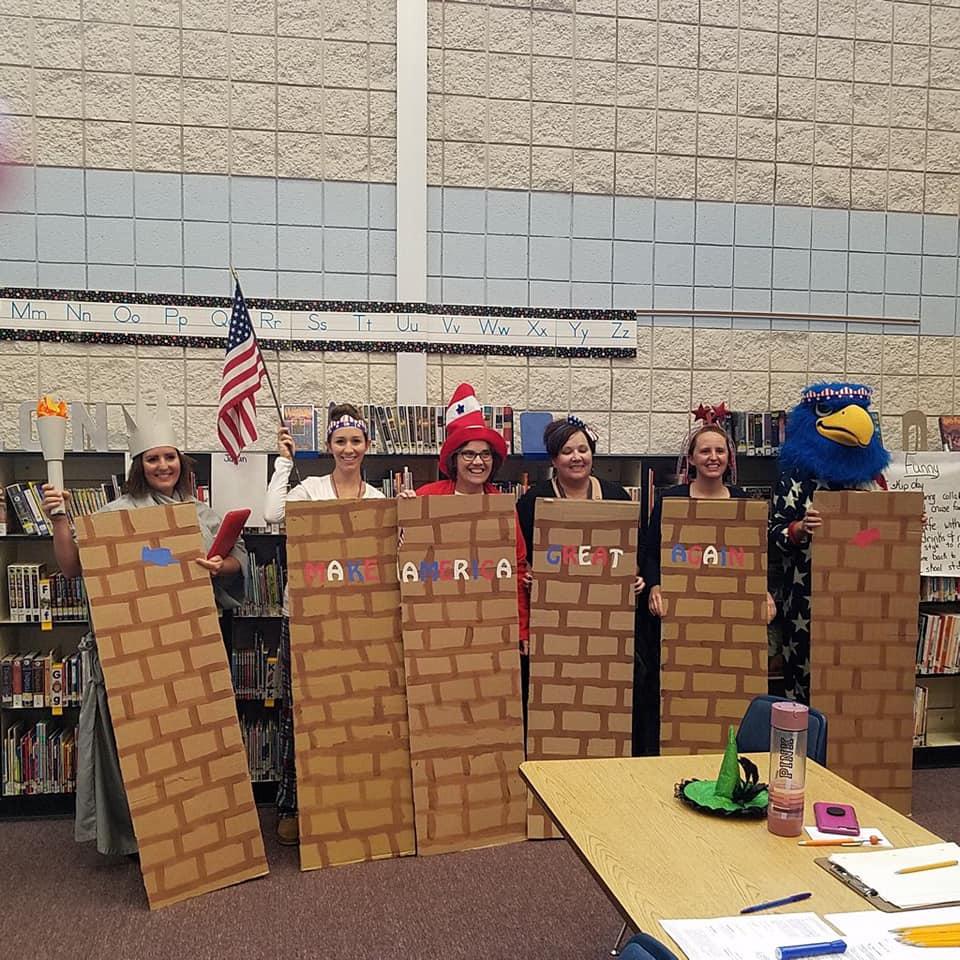 caption: In another photo put on social media by the Middleton School District, educators can be seen posing with segments of a wall emblazoned with "Make America Great Again." CREDIT:  Middleton Heights School District via Facebook