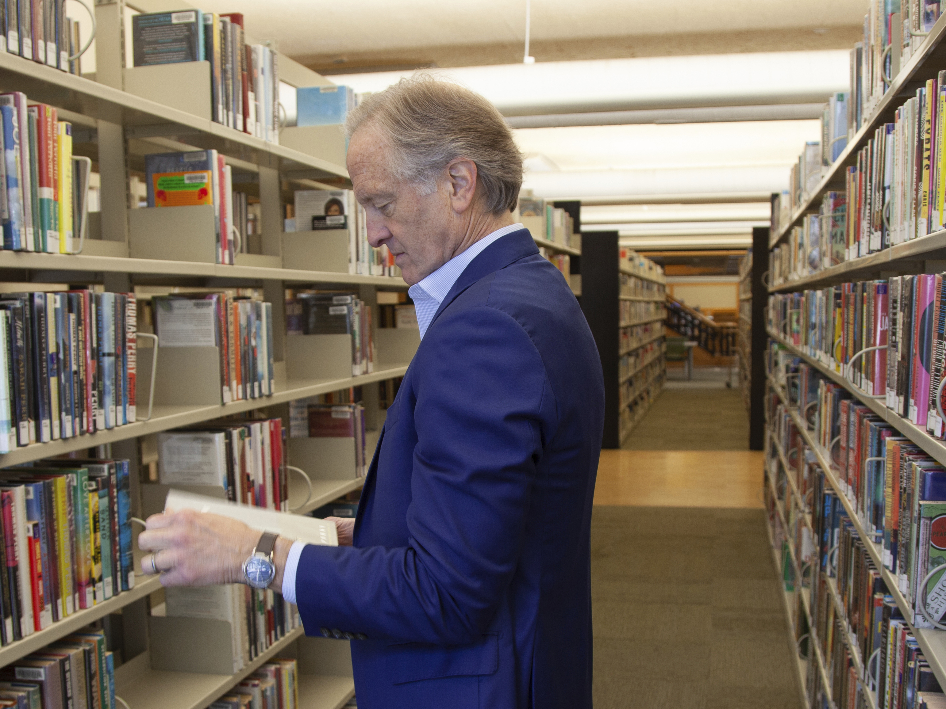 caption: Nate Coulter, executive director of the Central Arkansas Library System (CALS), looks at a book in the main branch of the public library in downtown Little Rock, Ark., on May 23, 2023. Arkansas is temporarily blocked from enforcing a law that would have allowed criminal charges against librarians and booksellers for providing "harmful" materials to minors, a federal judge ruled Saturday, July 29.