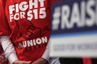 caption: An activist wears a "Fight For $15 and a Union" t-shirt at the U.S. Capitol in 2019 as lawmakers took on legislation to raise the federal minimum wage.