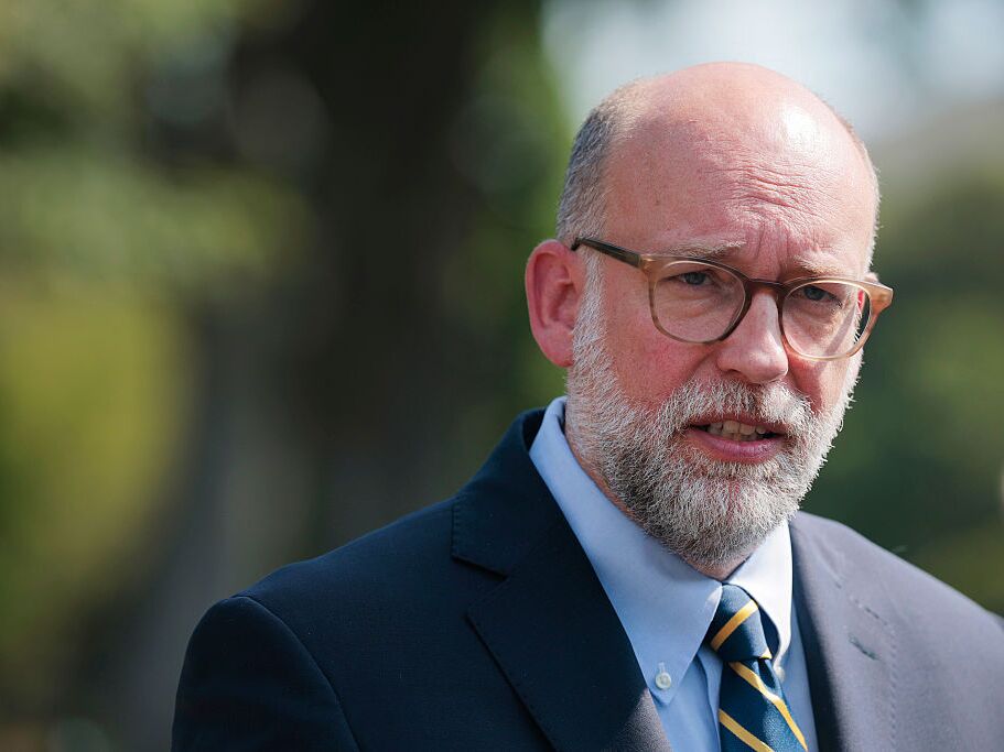 caption: Russell Vought, director of the Office of Management and Budget (OMB), speaks with reporters outside of the West Wing of the White House in July 2025.