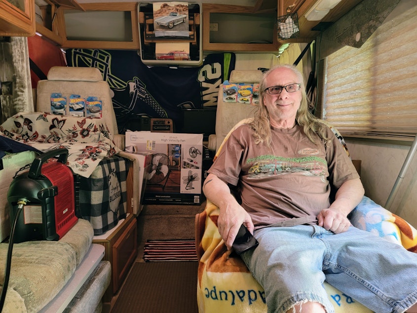 caption: Keith Roberts sits in his RV next to a space heater on Saturday, May 20, 2023. 