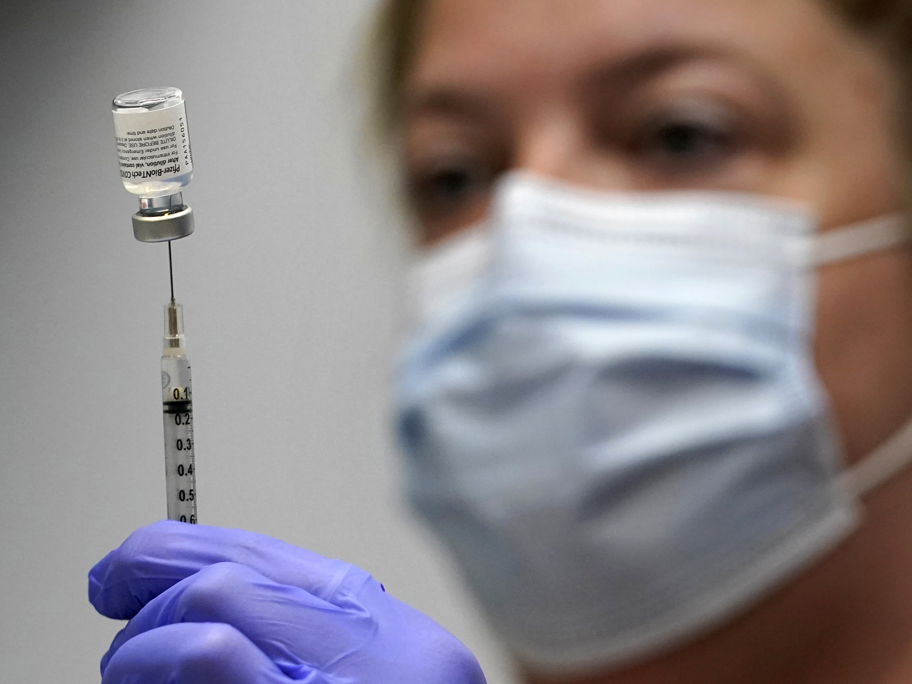caption: In this March photo, pharmacy technician Hollie Maloney loads a syringe with Pfizer's COVID-19 vaccine at the Portland Expo in Portland, Maine. The U.S. gave full approval to Pfizer and BioNTech's COVID-19 vaccine on Monday.