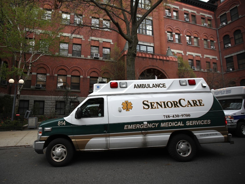 caption: An ambulance pulls up outside a nursing home in Brooklyn, N.Y. Two senators have called for an investigation of five states, including New York, which ordered nursing homes to admit patients who tested positive for COVID-19.