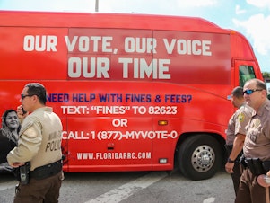 caption: A tour bus, sponsored by the Florida Rights Restoration Coalition, pulls up to a Miami-Dade County courthouse ahead of a hearing aimed at restoring the right to vote under Florida's Amendment 4 on Nov. 8, 2019.