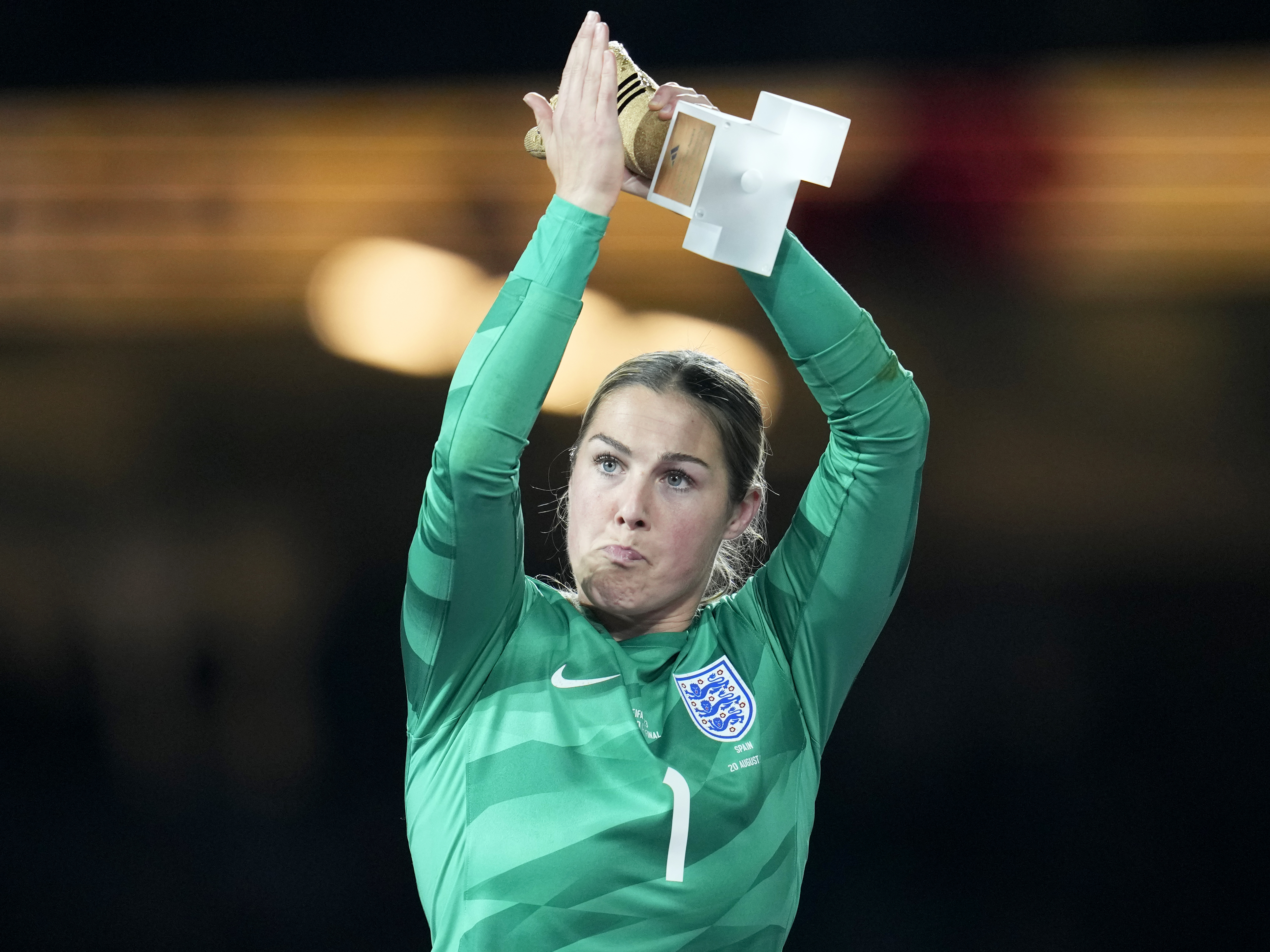 caption: England's goalkeeper Mary Earps applauds after receiving the Golden Glove award for the tournament's best goalkeeper, at the end of the Women's World Cup soccer final between Spain and England in Sydney, Australia, Sunday, Aug. 20, 2023.