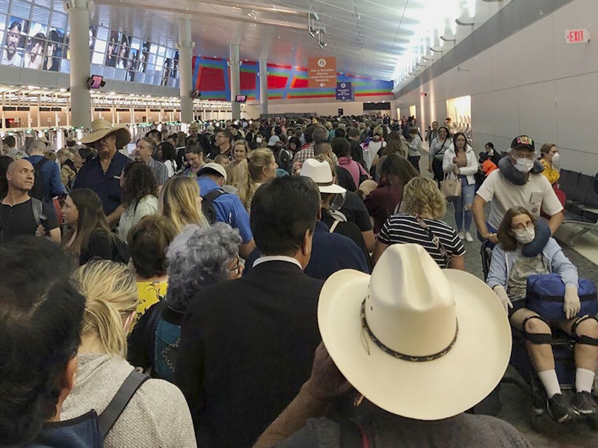 caption: People waited in line to go through the customs at Dallas/Fort Worth International Airport on Saturday as staff took extra precautions to guard against the coronavirus.