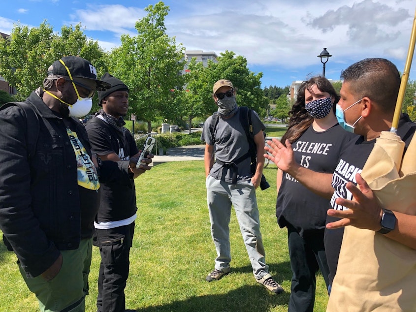 caption: After the rally, Burien Mayor Jimmy Matta gets tough questions from Beezie 2000 and Darryl King Jr (Who raps as TNT, The Natural Truth). The two challenged his positive view of the police.