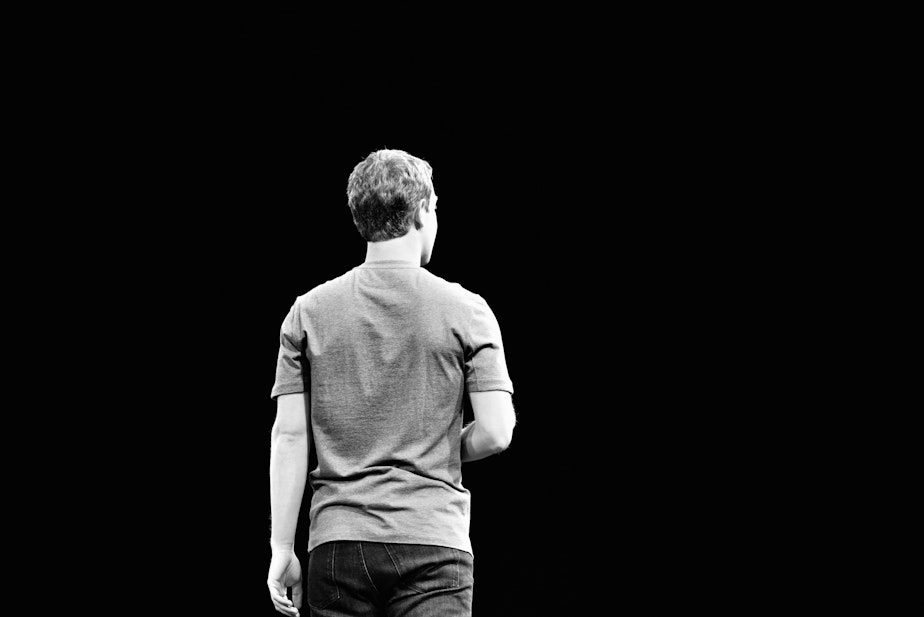 caption: Facebook CEO Mark Zuckerberg, turning his back on the camera as we might wish to turn our backs on his network.