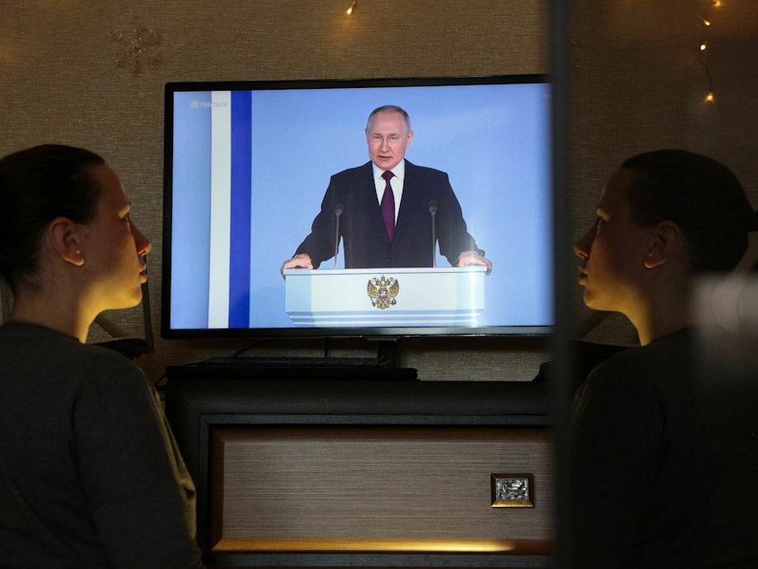 caption: A woman in Simferopol, Crimea, watches a TV broadcast of Russian President Vladimir Putin's annual state of the nation address on Tuesday. Putin announced Russia is suspending participation in the New START nuclear weapons treaty.