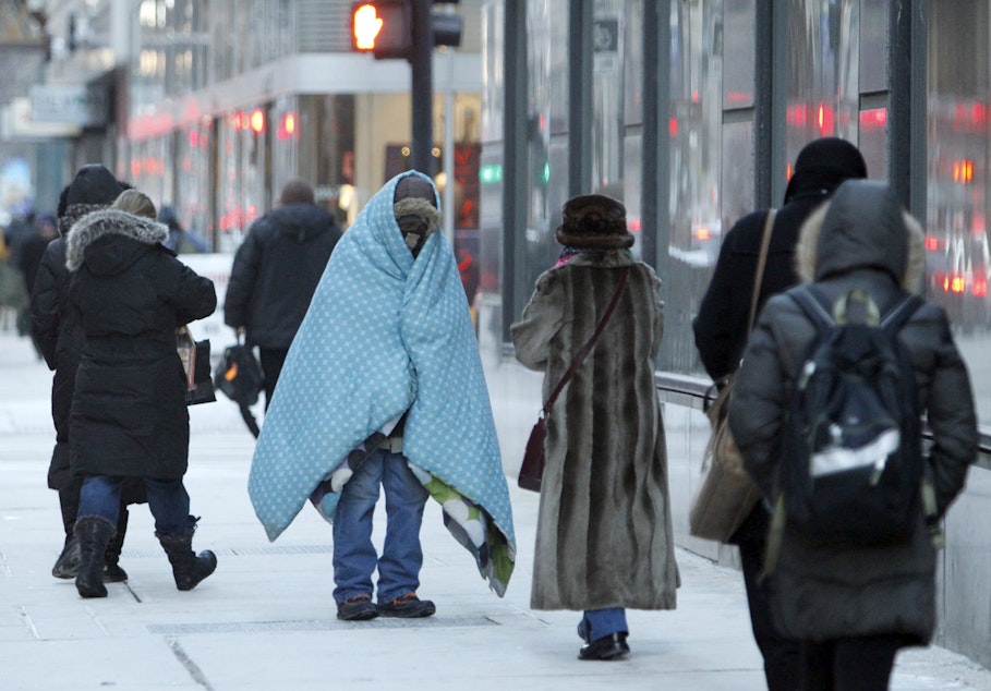 caption: A homeless man who did not give his name bundles up in blankets in downtown Chicago during a deep freeze. (Kiichiro Sato/AP)
