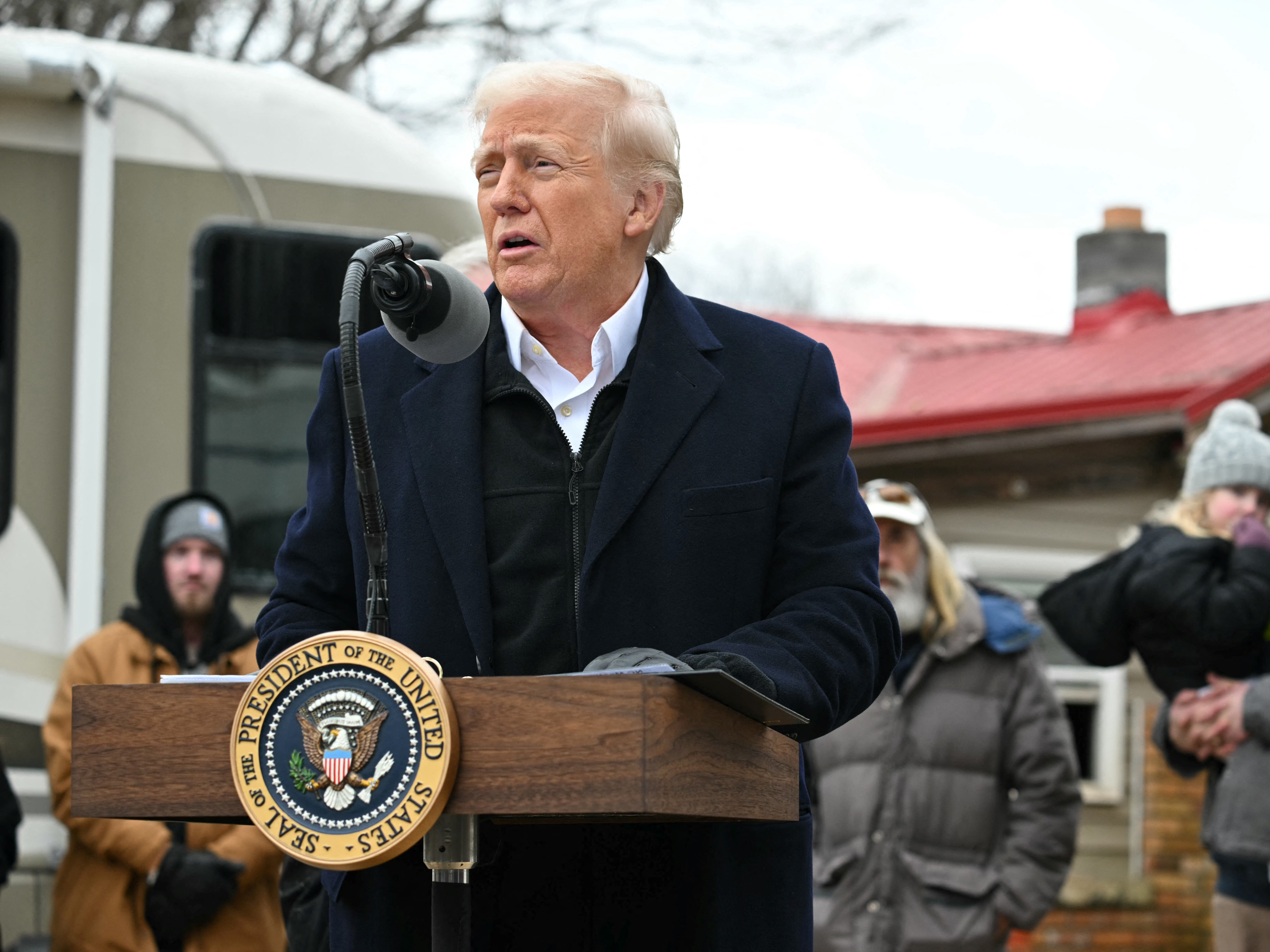 caption: President Trump gets a briefing from officials in North Carolina about the recovery from Hurricane Helene in a hangar in Asheville, N.C. on Jan. 24, 2025.