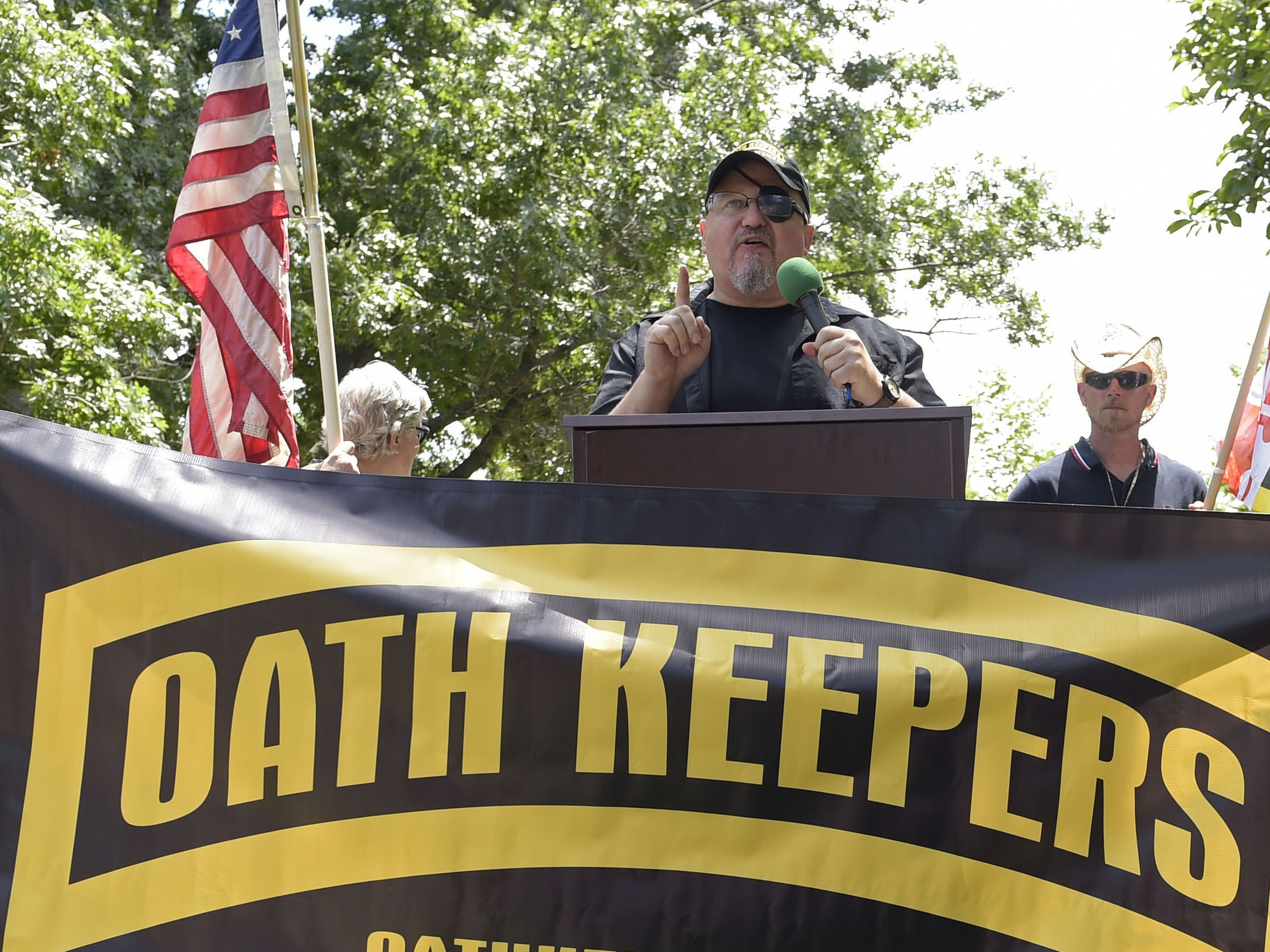 caption: Stewart Rhodes, founder of the Oath Keepers, center, speaks during a rally outside the White House in Washington on June 25, 2017.