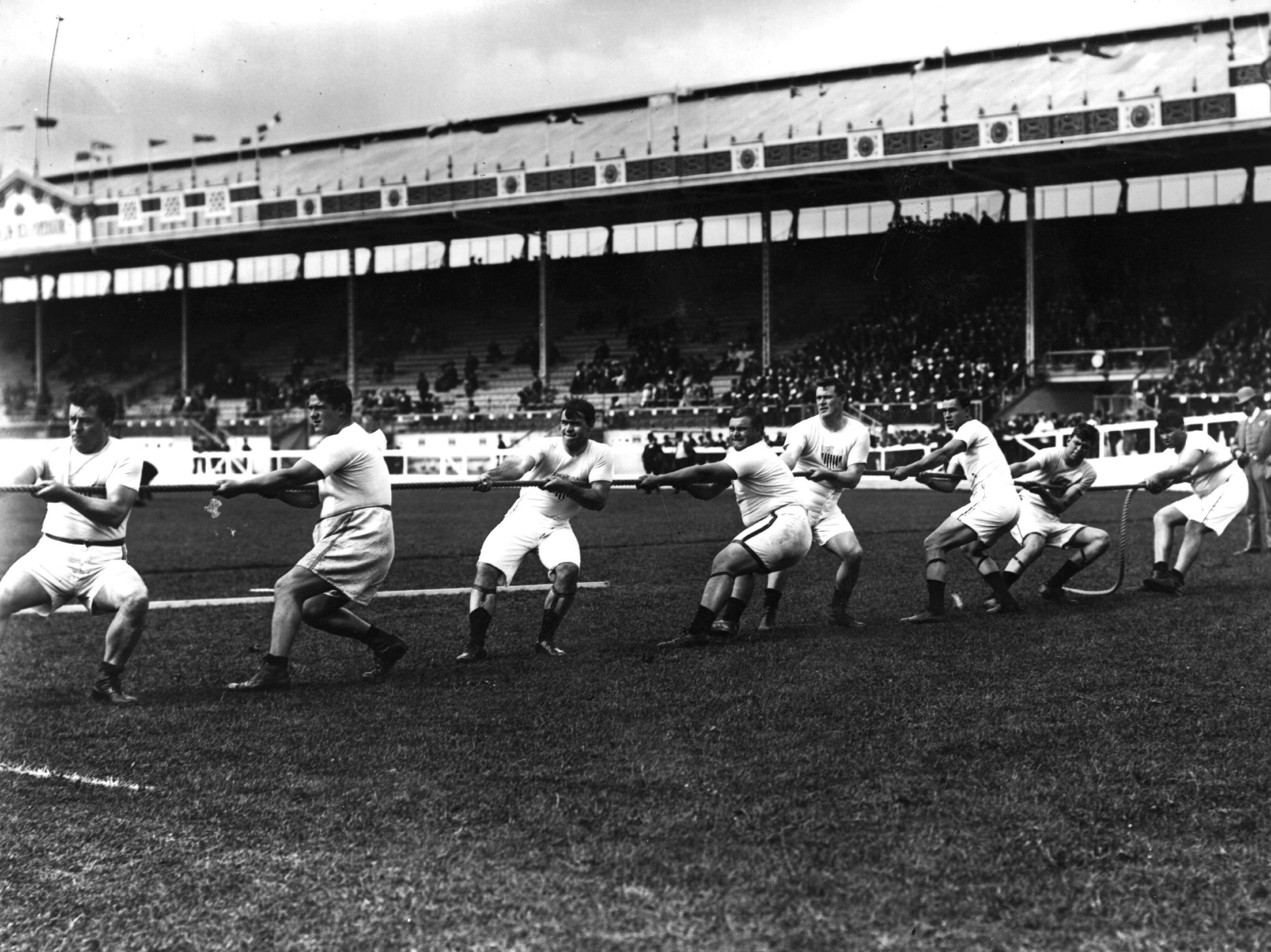 caption: The Unites States tug-of-war team in action during the 1908 London Olympics at White City Stadium.